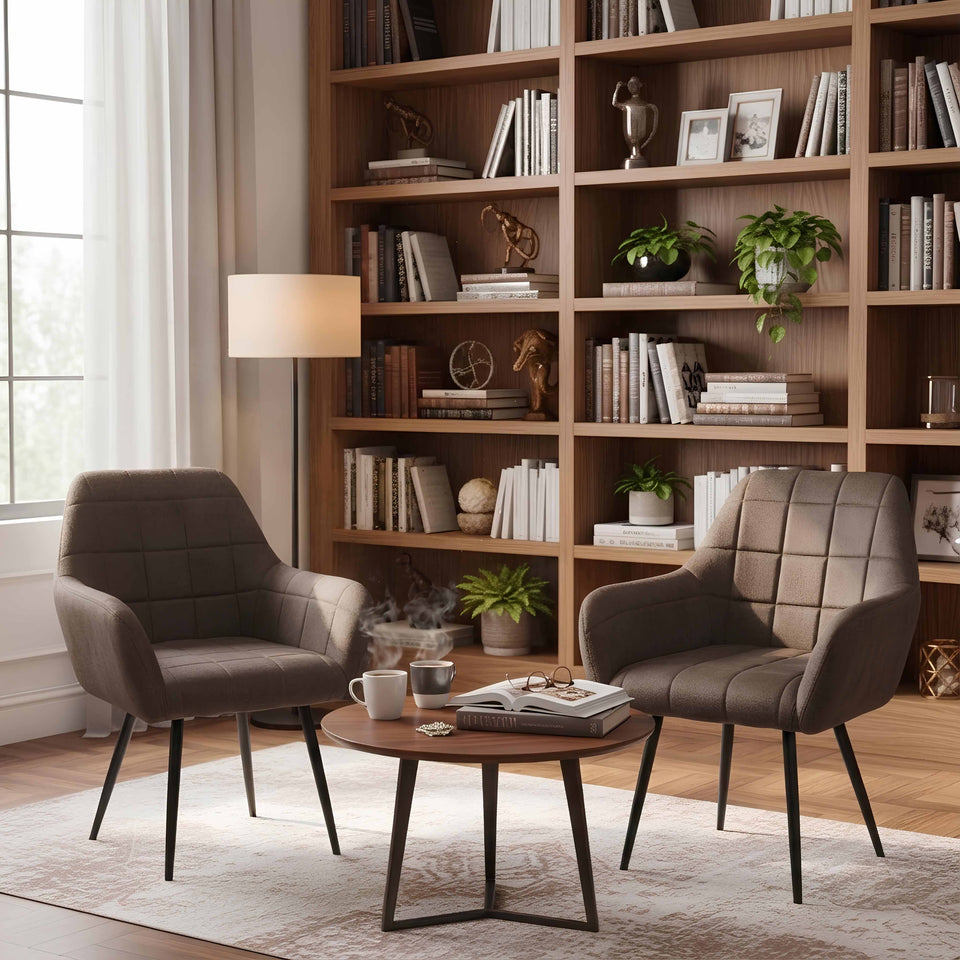 Modern living room with two brown chairs, a coffee table, and a bookshelf filled with books and decor.
