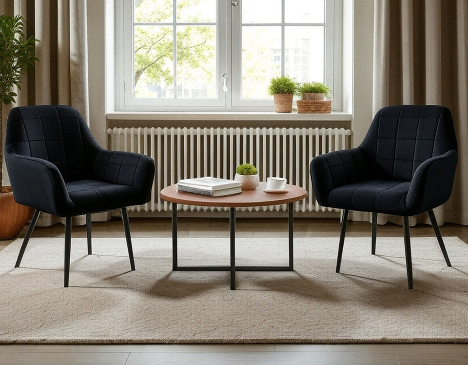 Two black Wilhelm armchairs with armrests next to a wooden coffee table in an elegant living room