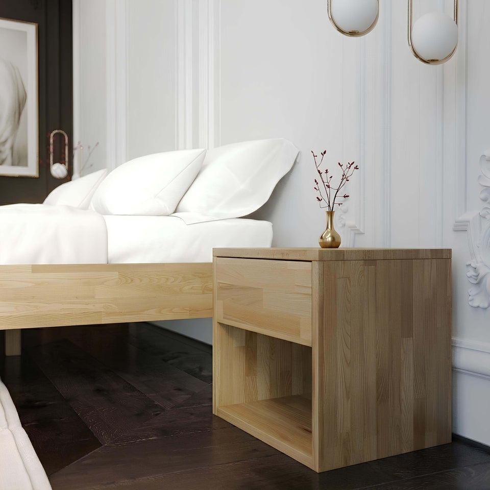 Oak wood bedside table in the bedroom next to the bed